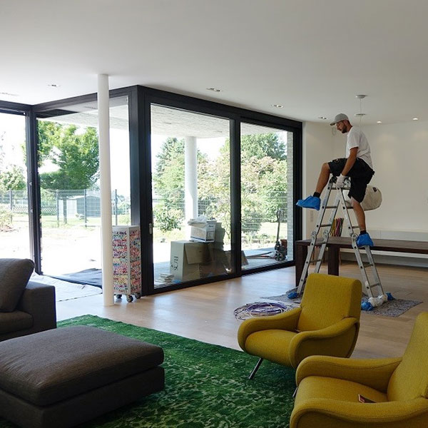 Moderner Wohnraum mit Glaswänden zur überdachten Terrasse