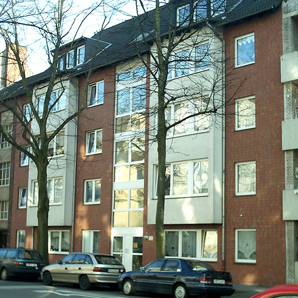 Kahle Bäume vor der Fassade eines Hauses mit Seniorenwohnungen